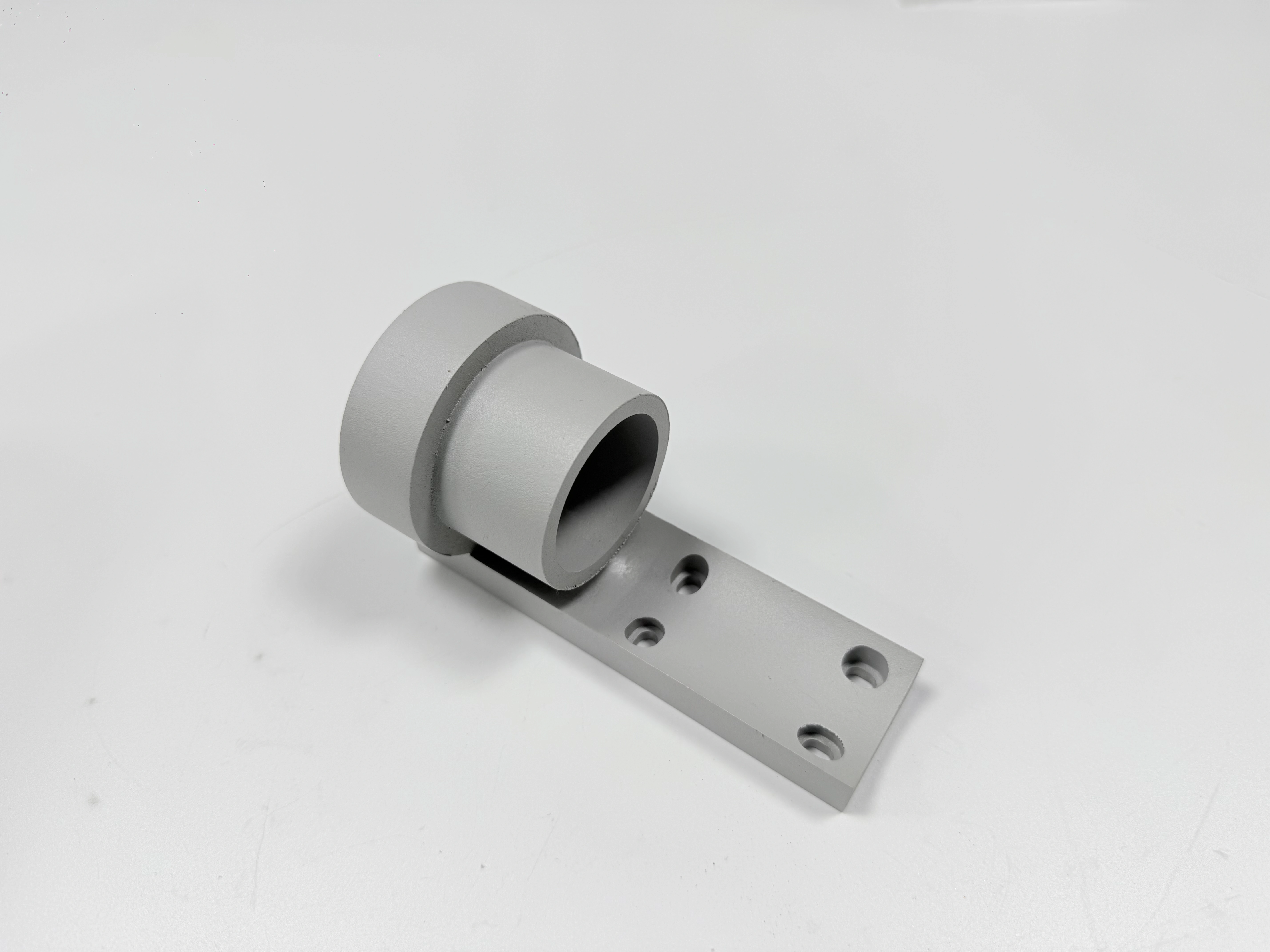 Alternate view of the same white-finished bracket showing the bore, flange, and mounting holes