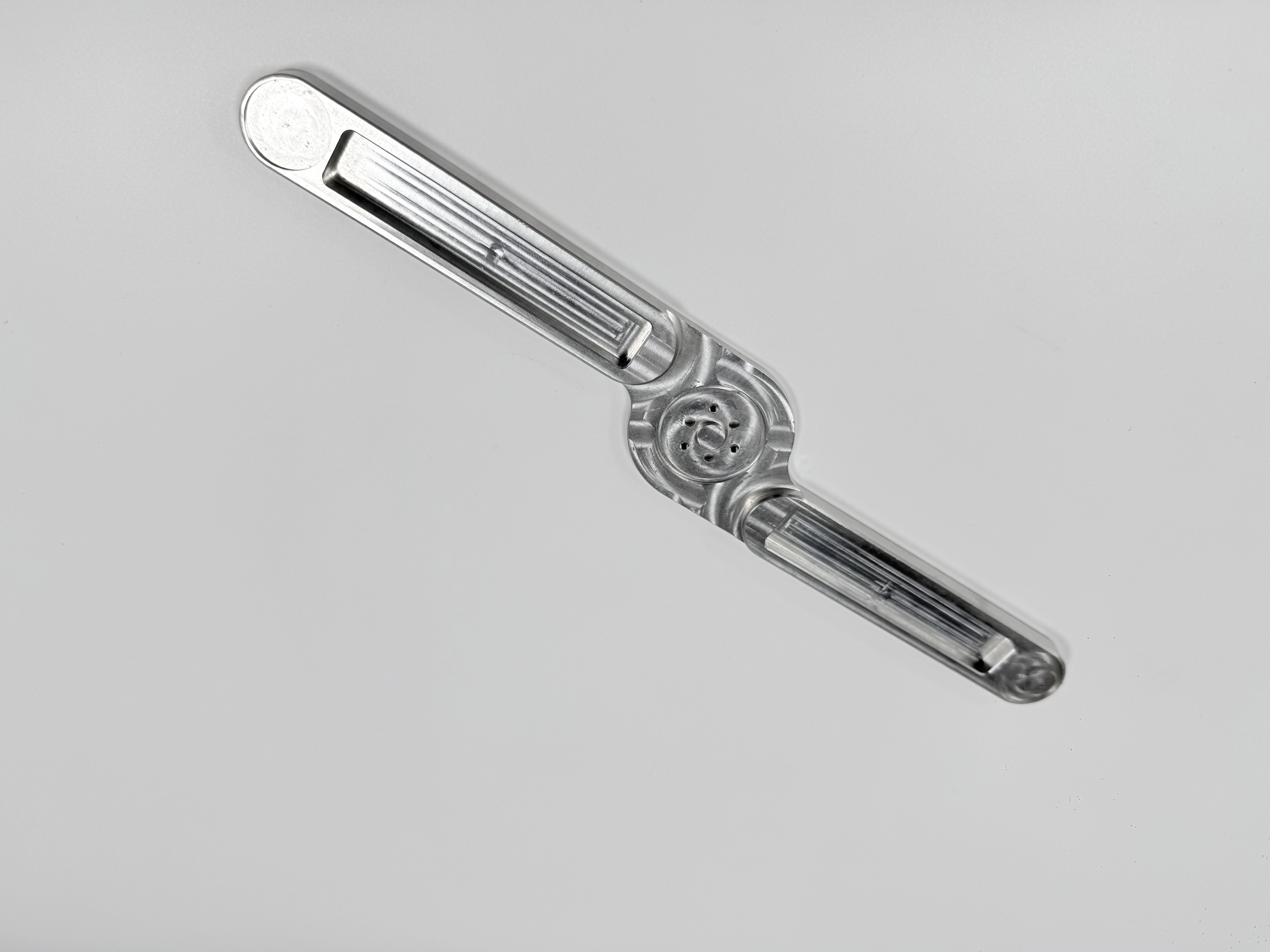 The same polished link arm prototype viewed from an angled perspective
